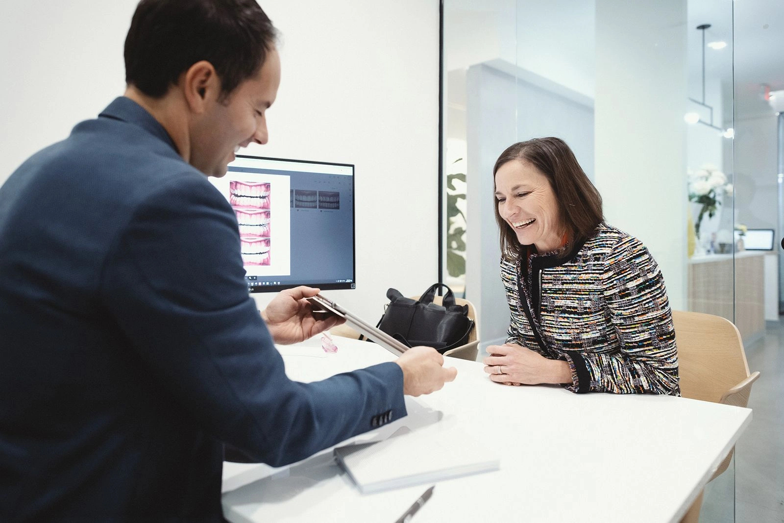 A dentist explaining a treatment plan to a patient using dental images