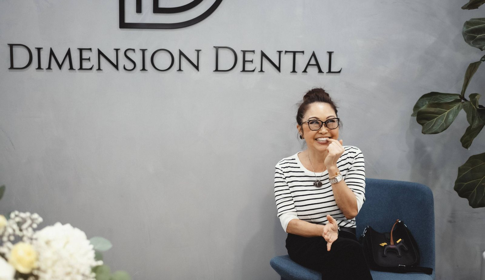 A girl with a restored smile is sitting in the chair at Dimension Dental office