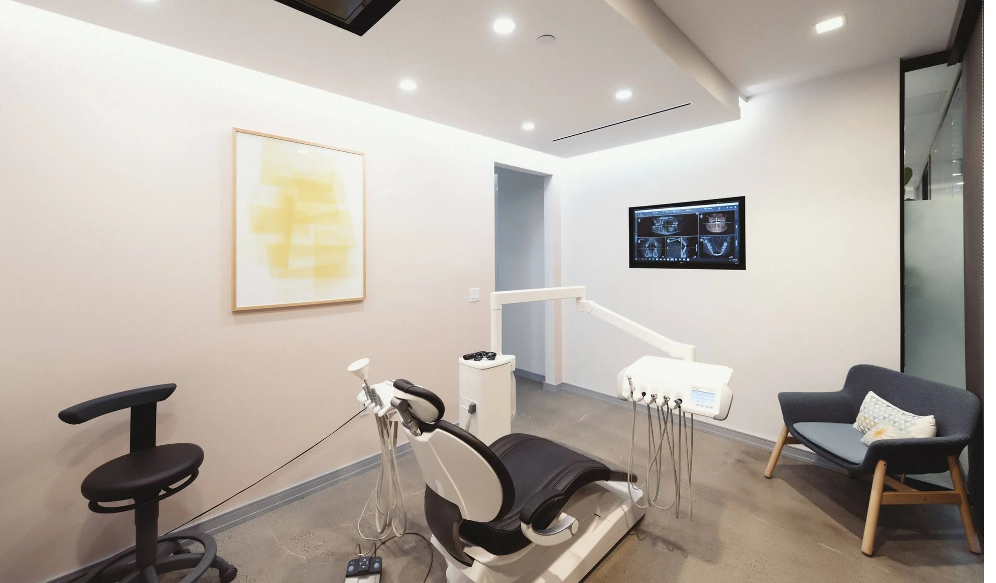 Dentist chair with dental tools and visible X-ray setup at Dimension Dental in Holmdel