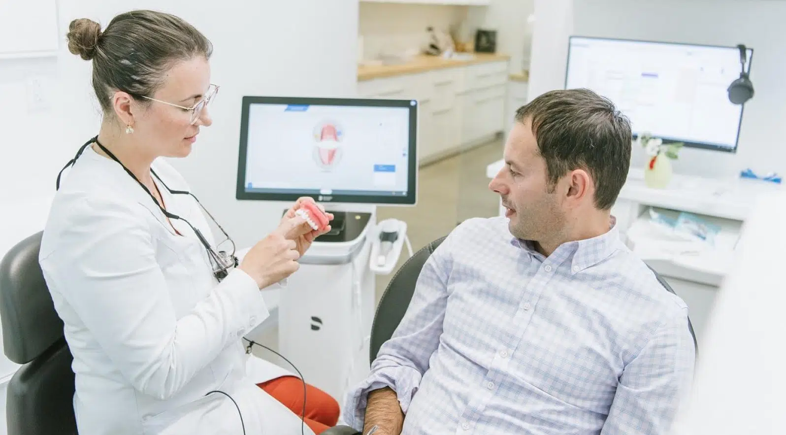 A dentist explaining a treatment plan to a patient using dental images